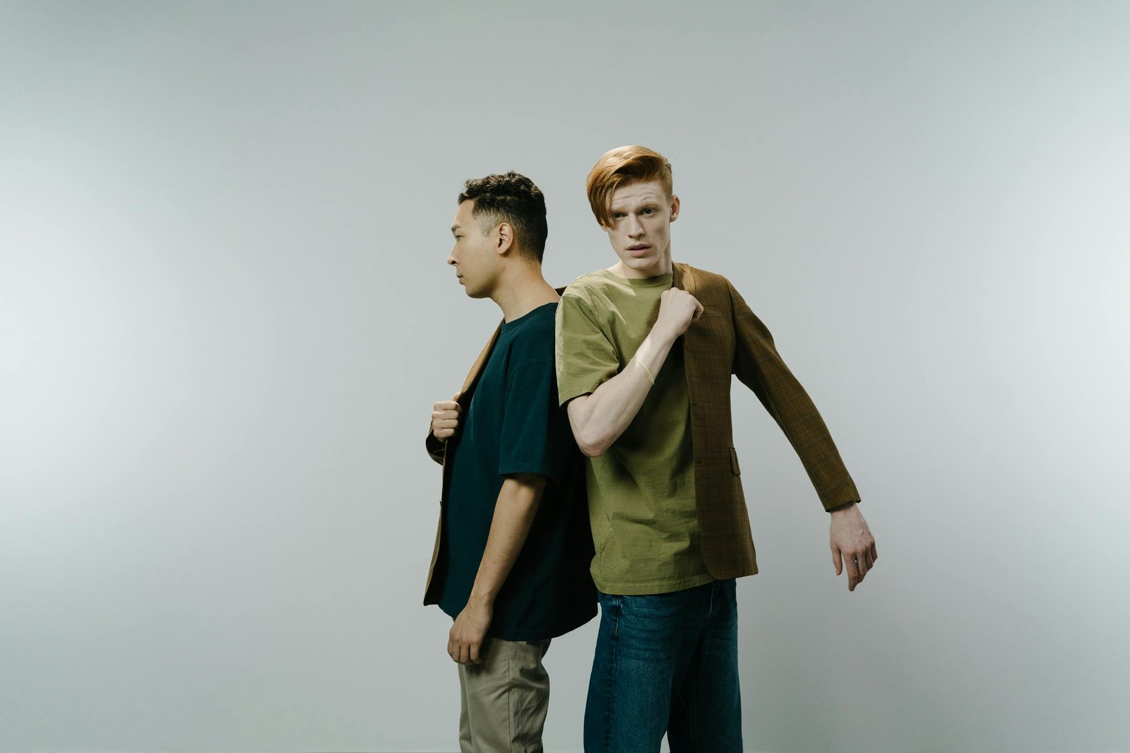 Two men in a studio facing different directions, conveying disconnection.